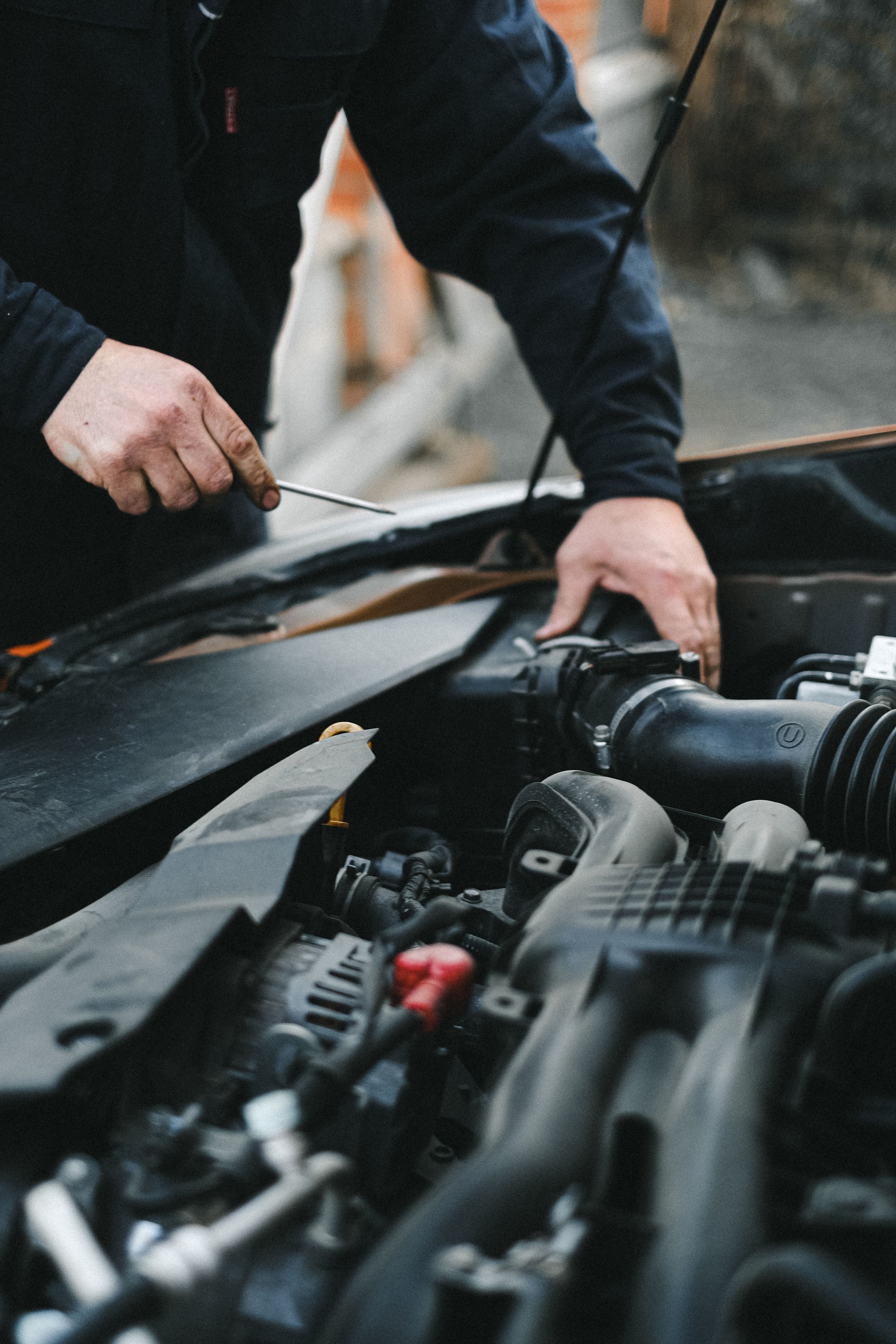 A mechanic servicing a car at Imperium Auto Inc.